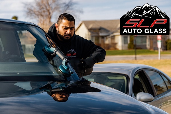 SLP Auto Glass technician using suction cups to install a windshield during a mobile service.