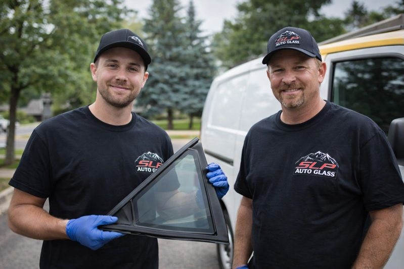 SLP Auto Glass technician holding quarter glass during autoglass replacement in Lakewood and Denver