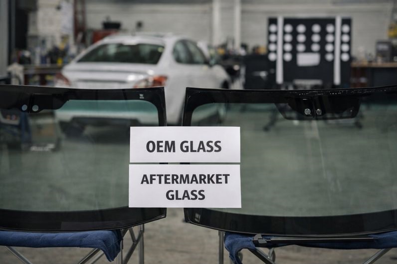 OEM and aftermarket windshield glass displayed in an auto glass shop for professional replacement services by SLP AutoGlass