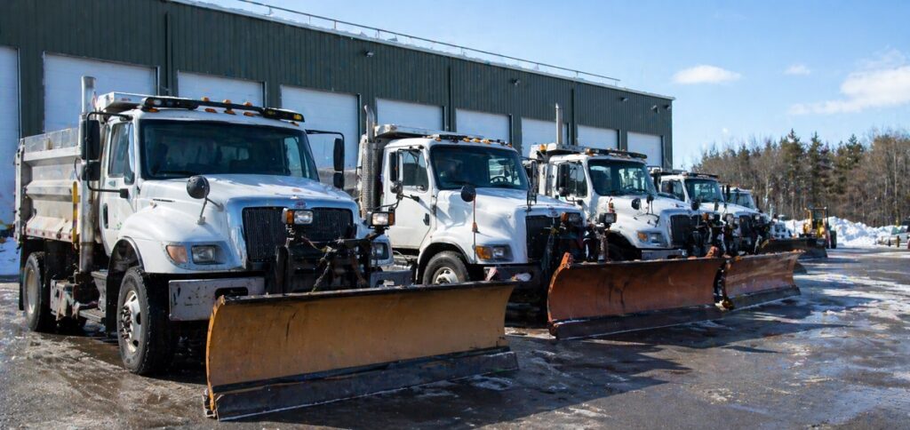 Fleet of snowplow trucks ready for windshield maintenance and replacement