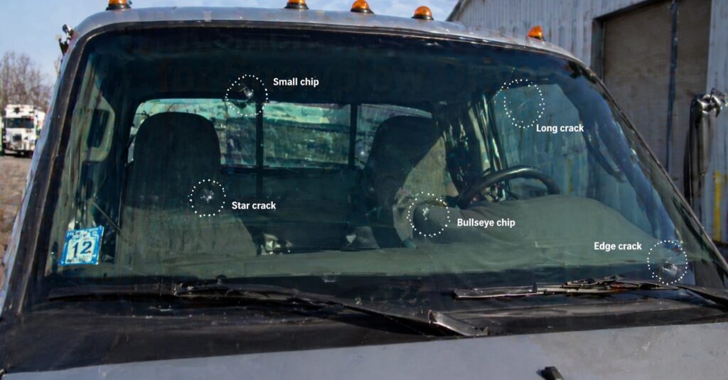 Windshield chips and cracks indicating need for replacement on work truck