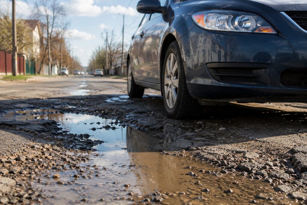 Car driving over potholes on rough roads to help prevent windshield cracks